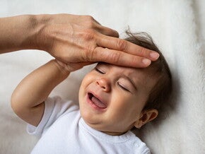 Мама перевіряє температуру у дитини Мама перевіряє температуру у дитини